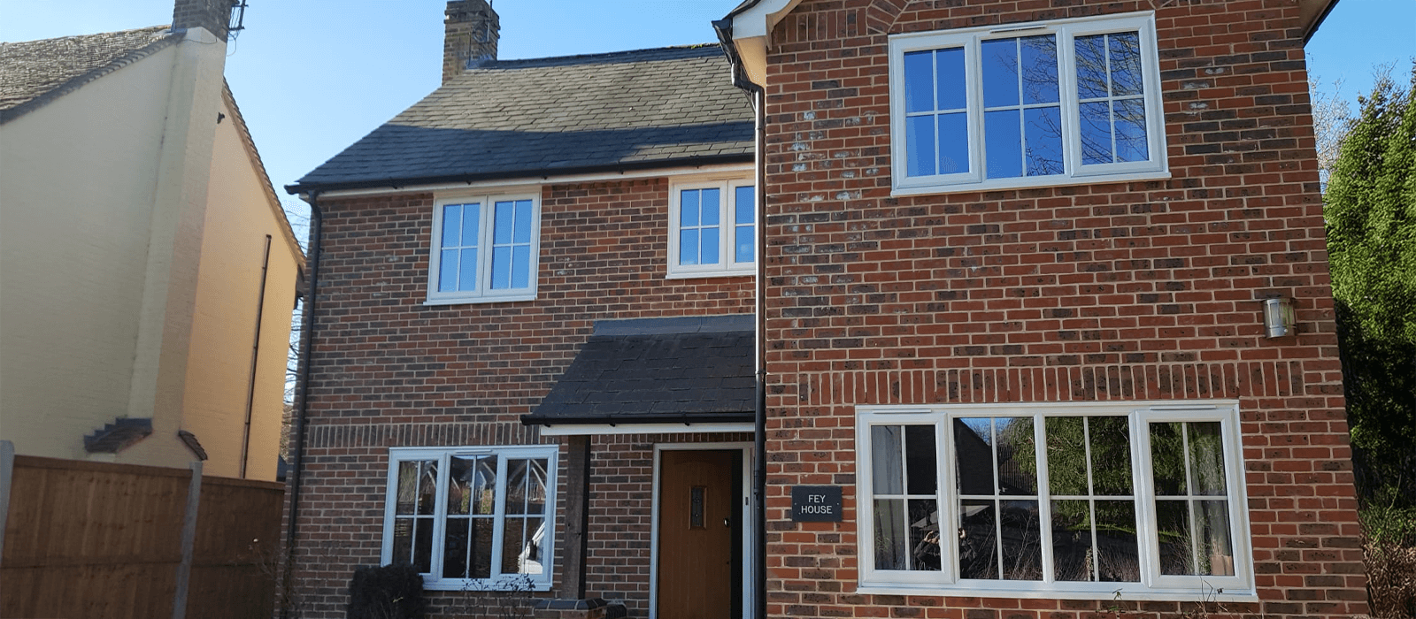 White uPVC casement windows installed on a traditional brick house, enhancing energy efficiency and security.
