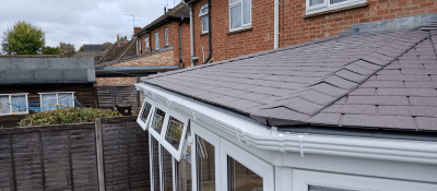 Grey tiled conservatory roof installed on a white-framed conservatory, providing improved insulation and weather protection.