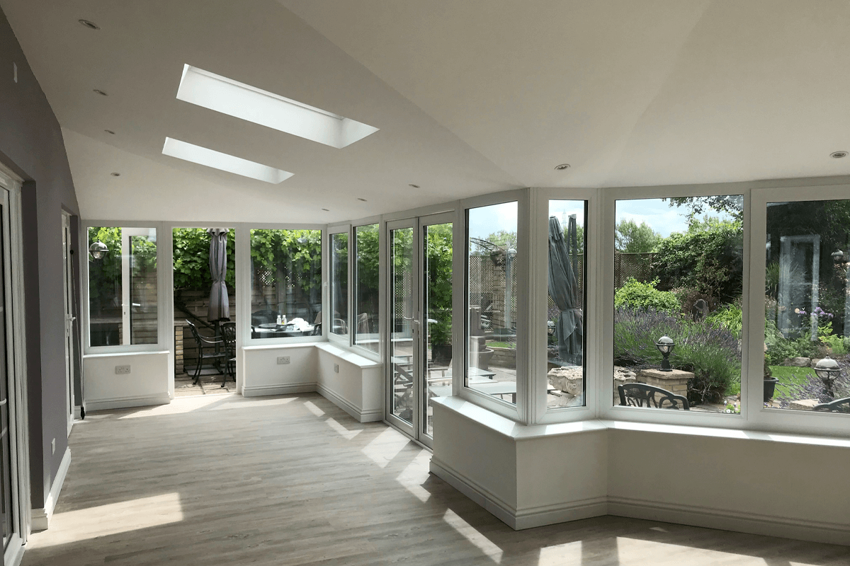 Tiled roof conservatory interior with large windows and skylights, providing a bright and energy-efficient living space.